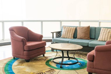 Boş kanepe ve yastıklı sandalye bir odada.