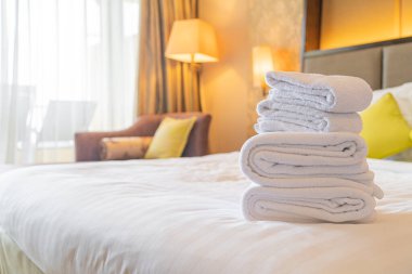 Otel odasında beyaz havlu katlanır.