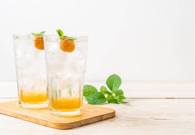 Sodayla buzlu erik suyu ve ahşap masada nane şekeri - içecek.