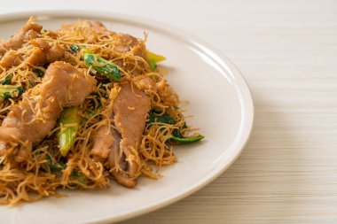 Kızarmış pirinç vermicelli şehriyeli, siyah soya soslu ve domuz etli, Asya usulü.