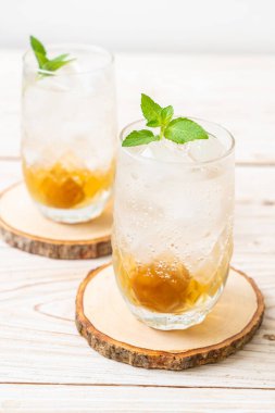 Sodayla buzlu erik suyu ve ahşap masada nane şekeri - içecek.