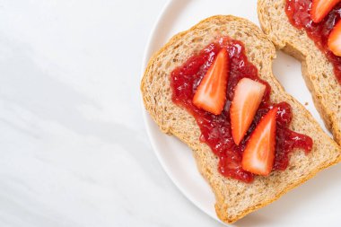Çilek reçelli ve taze çilekli ev yapımı tam buğday ekmeği.