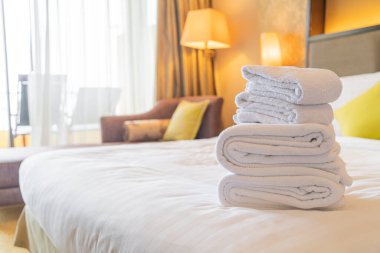 Otel odasında beyaz havlu katlanır.