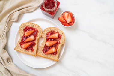 Çilek reçelli ve taze çilekli ev yapımı tam buğday ekmeği.