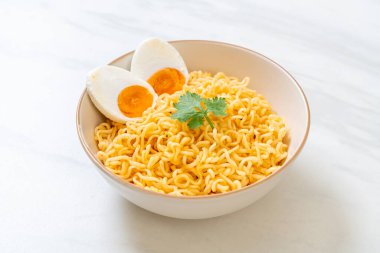 Hazır erişte kasesi ve tuzlu yumurta.