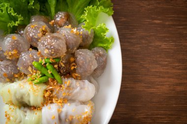 Şeffaf toplara Saku Sai Moo ya da Buharlı Tapioca Köfte Topları ve (Kow Griep Pag Mor) Domuz Buharlı Pirinç Paketleri ya da Haşlanmış Pirinç Kabuklu Mantı denir.