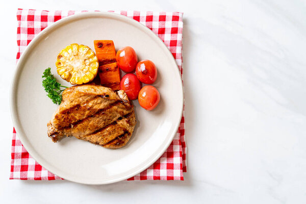 grilled and barbecue fillet pork steak with corn, carrot and tomatoes