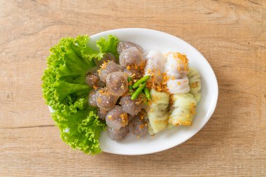 Şeffaf toplara Saku Sai Moo ya da Buharlı Tapioca Köfte Topları ve (Kow Griep Pag Mor) Domuz Buharlı Pirinç Paketleri ya da Haşlanmış Pirinç Kabuklu Mantı denir.