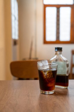 Ahşap masada buz küplü soğuk kahve bardağı.