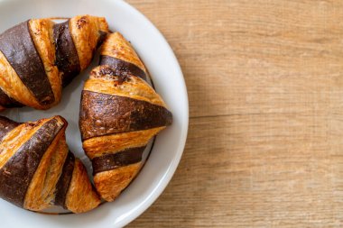 Tabağında çikolata olan taze kruvasan.