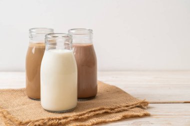Çikolatalı süt, kahve ve taze sütün ahşap arka planda toplanması