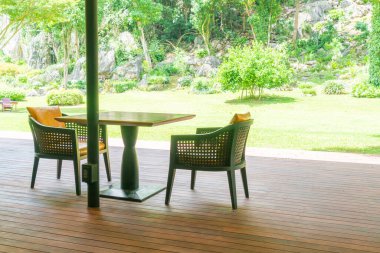Bahçe sandalyesi ve balkondaki bahçe arka planlı masa.