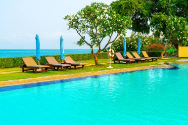 Havuz kenarındaki havuz, havuz, şemsiye, deniz manzaralı havuz tatilleri ve tatil konsepti.