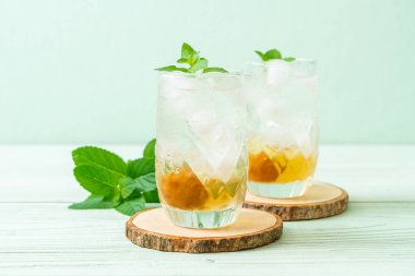 Sodayla buzlu erik suyu ve ahşap masada nane şekeri - içecek.