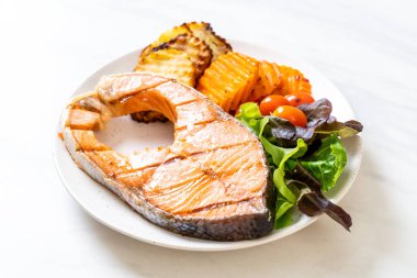 Kızarmış somon bifteği fileto, sebze ve patates kızartması.