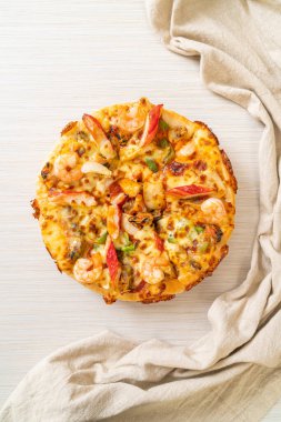 Tahta tepside deniz ürünleri (karides, ahtapot, midye ve yengeç) pizza