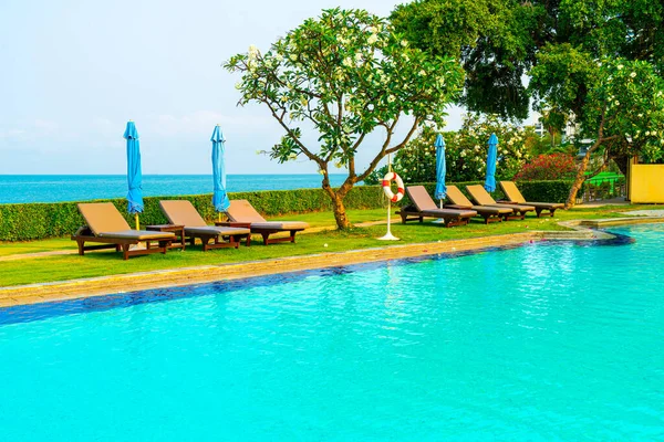 Havuz kenarındaki havuz, havuz, şemsiye, deniz manzaralı havuz tatilleri ve tatil konsepti.