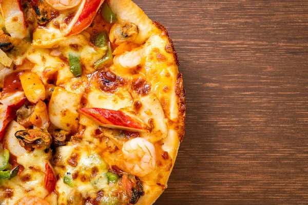 Tahta tepside deniz ürünleri (karides, ahtapot, midye ve yengeç) pizza