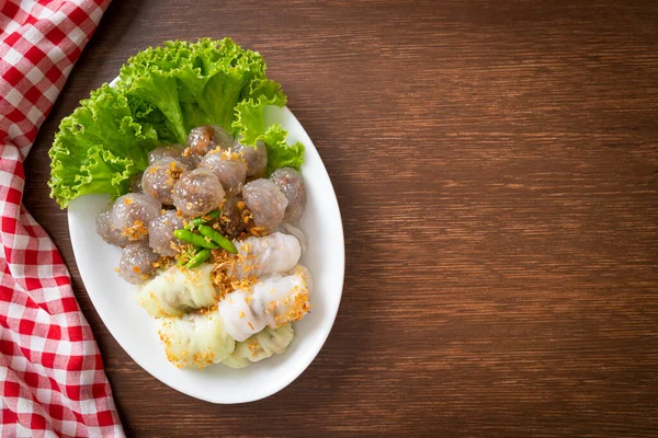 Şeffaf toplara Saku Sai Moo ya da Buharlı Tapioca Köfte Topları ve (Kow Griep Pag Mor) Domuz Buharlı Pirinç Paketleri ya da Haşlanmış Pirinç Kabuklu Mantı denir.