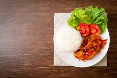 Üç çeşnili kızarmış balık. Beyaz tabakta pilav ve kırmızı biber sosu.