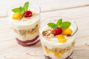 Ev yapımı taze mango ve yoğurt ve granola ile taze ahududu. Sağlıklı yemek tarzı.