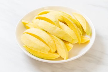 Tabakta taze yeşil ve altın mango dilimi