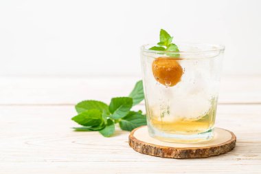 Sodayla buzlu erik suyu ve ahşap masada nane şekeri - içecek.