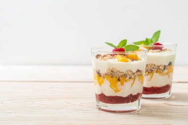 Ev yapımı taze mango ve yoğurt ve granola ile taze ahududu. Sağlıklı yemek tarzı.
