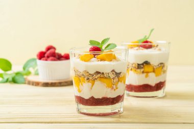 Ev yapımı taze mango ve yoğurt ve granola ile taze ahududu. Sağlıklı yemek tarzı.