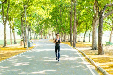 Parkta koşan Asyalı kadın.