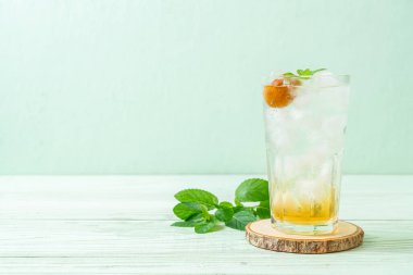 Sodayla buzlu erik suyu ve ahşap masada nane şekeri - içecek.