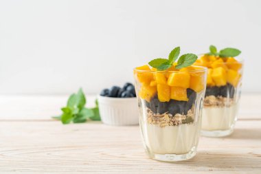 Ev yapımı taze mango ve yoğurt ve granola ile taze yaban mersini. Sağlıklı yemek tarzı.