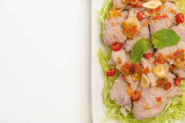 Baharatlı domuz salatası ya da limon sarımsaklı haşlanmış domuz eti ve beyaz arka planda izole edilmiş acılı sos.