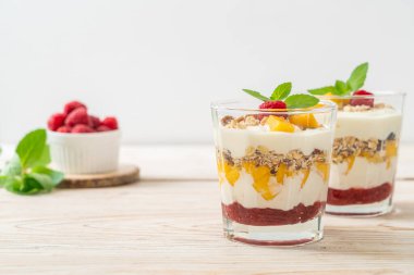 Ev yapımı taze mango ve yoğurt ve granola ile taze ahududu. Sağlıklı yemek tarzı.