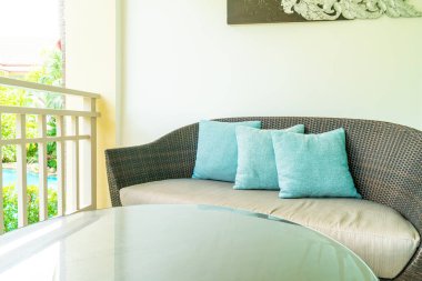 Balkondaki teras sandalyesinde rahat yastık süslemesi