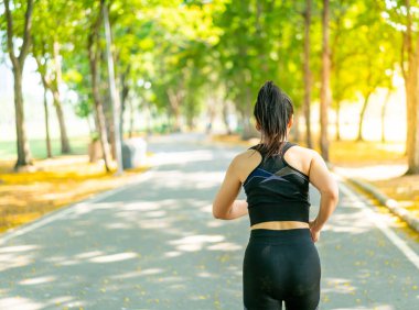 Parkta koşan Asyalı kadın.