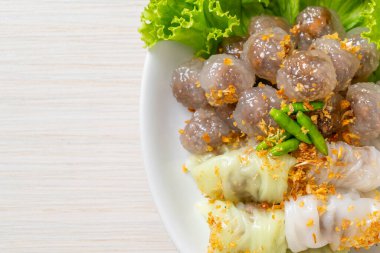 Şeffaf toplara Saku Sai Moo ya da Buharlı Tapioca Köfte Topları ve (Kow Griep Pag Mor) Domuz Buharlı Pirinç Paketleri ya da Haşlanmış Pirinç Kabuklu Mantı denir.