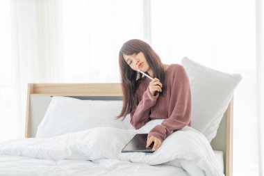 Yatakta tabletle çalışan güzel Asyalı kadınlar