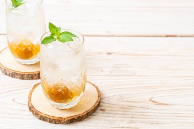 Sodayla buzlu erik suyu ve ahşap masada nane şekeri - içecek.