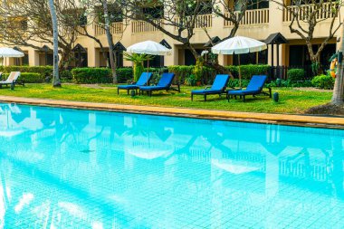Otelde ve tatil beldesinde yüzme havuzunda güzel şemsiye ve sandalye - tatil ve tatil konseri