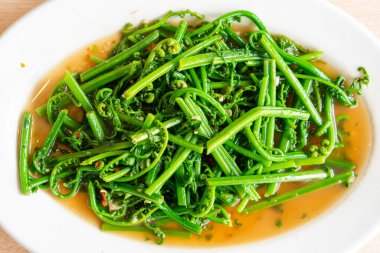 İstiridye soslu kavrulmuş berduş eğreltiotu. Asya usulü.