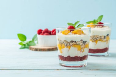 Ev yapımı taze mango ve yoğurt ve granola ile taze ahududu. Sağlıklı yemek tarzı.
