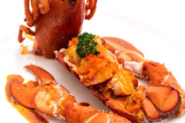 Soslu ıstakoz kuyruklu biftek ve beyaz arka planda karides yumurtaları.