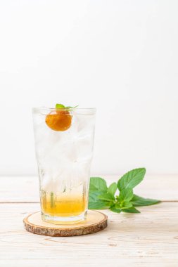 Sodayla buzlu erik suyu ve ahşap masada nane şekeri - içecek.