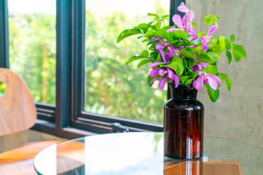 Kahve dükkanının masasında vazo süslemesindeki orkide çiçekleri.