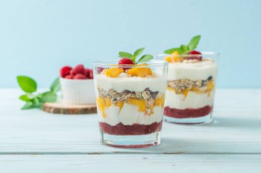 Ev yapımı taze mango ve yoğurt ve granola ile taze ahududu. Sağlıklı yemek tarzı.