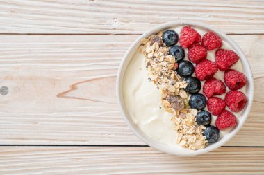 Ev yapımı yoğurt kasesi, ahududu, yaban mersini ve granola. Sağlıklı yemek tarzı.