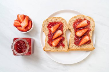 Çilek reçelli ve taze çilekli ev yapımı tam buğday ekmeği.