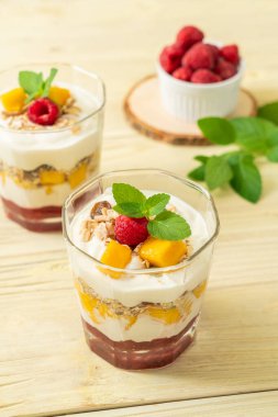 Ev yapımı taze mango ve yoğurt ve granola ile taze ahududu. Sağlıklı yemek tarzı.