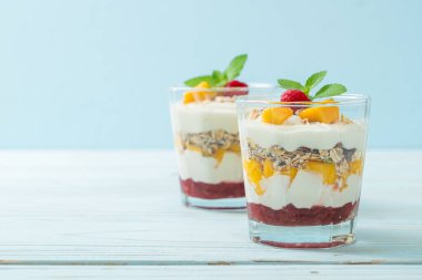 Ev yapımı taze mango ve yoğurt ve granola ile taze ahududu. Sağlıklı yemek tarzı.